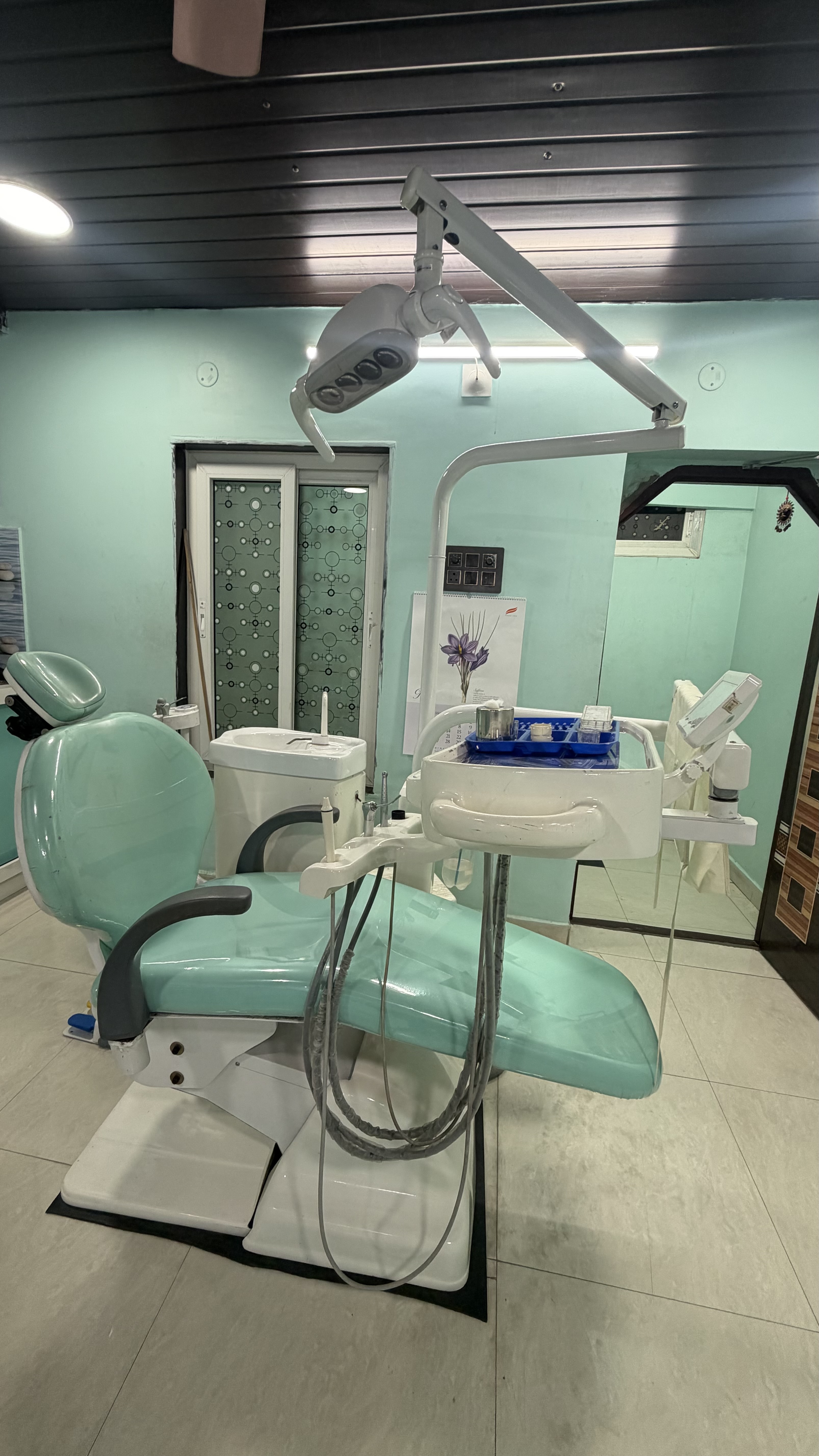 Close-up of mint-green dental chair and LED surgical illumination arm